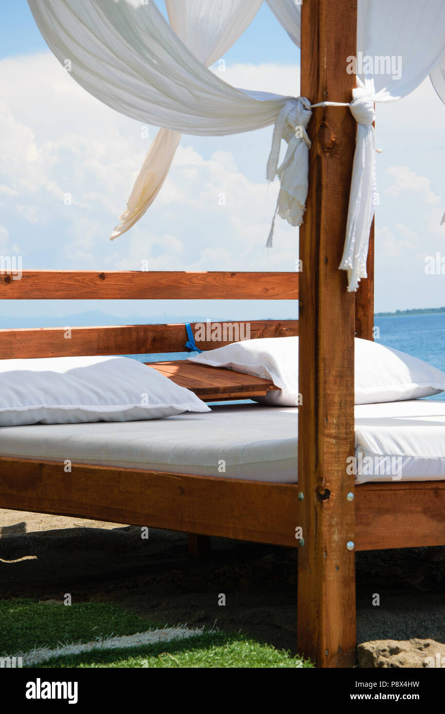 Lusso e romantico bed in riva al mare per i vostri momenti di relax (festività/vacanze), bianchi e soffici nuvole in background Foto Stock