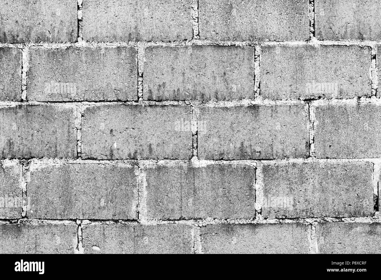 Vecchio muro costituito da blocchi di calcestruzzo di scorie come texture di sfondo in bianco e nero Foto Stock