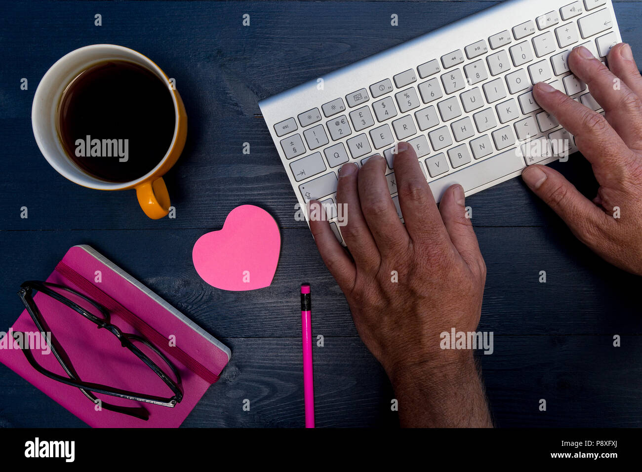 Uomo che lavora alla tastiera del computer sulla scrivania di legno la minima nozione di office Foto Stock