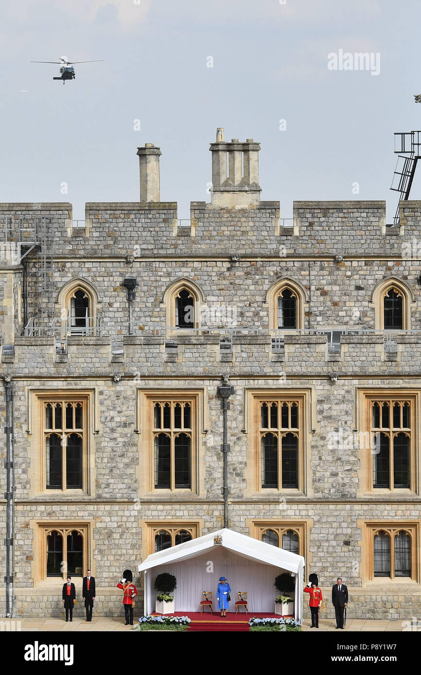 Queen Elizabeth II attende per salutare il Presidente statunitense Donald Trump come egli arriva in elicottero (superiore) al Castello di Windsor, Windsor. Foto Stock