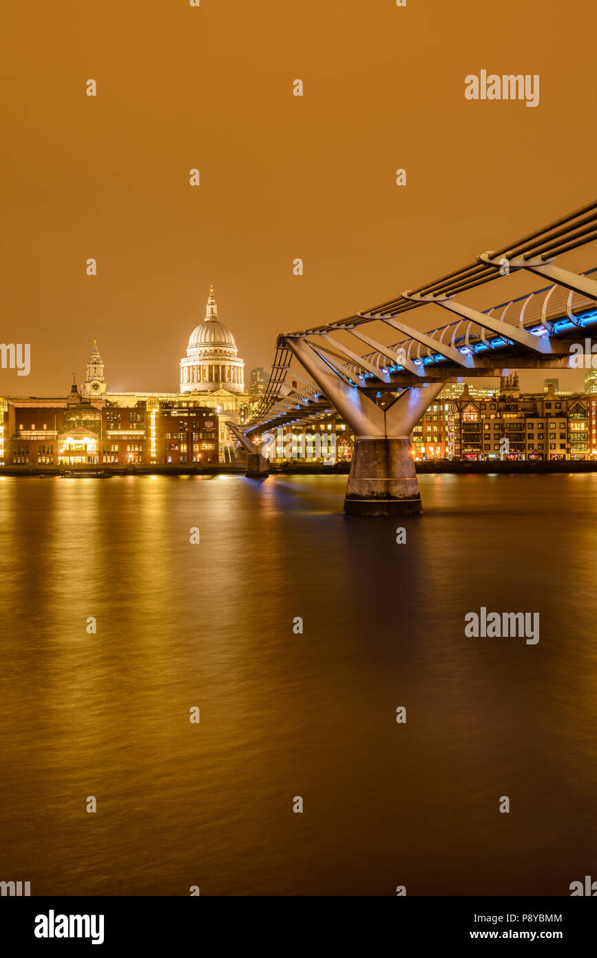 Una lunga esposizione visualizzazione verticale di St Pauls Cathedral e London Millennium Footbridge durante la notte con le luci riflesse nel fiume Tamigi Foto Stock