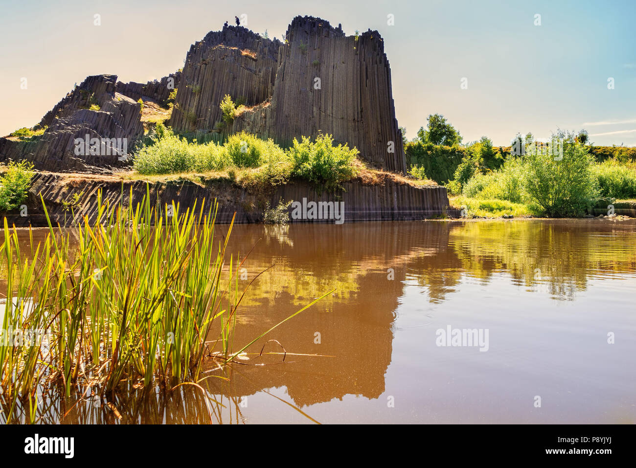 Roccia di basalto con la riflessione sulle acque del lago. Famoso paesaggio landmark chiamato Panska skala a Kamenicky Senov a nord della Repubblica ceca, 150 km nort Foto Stock