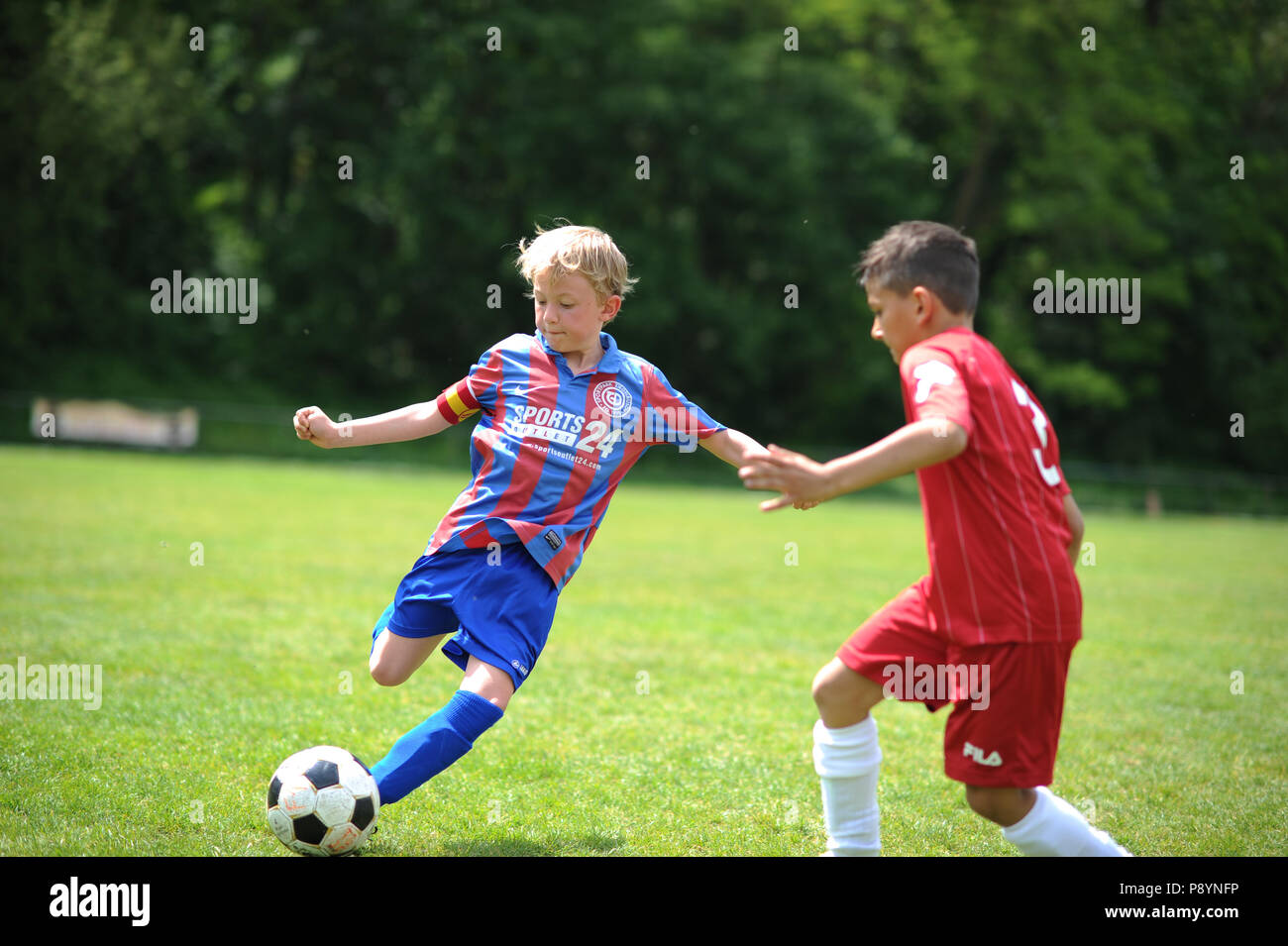 Bambini I bambini che giocano a calcio in jersey Foto Stock