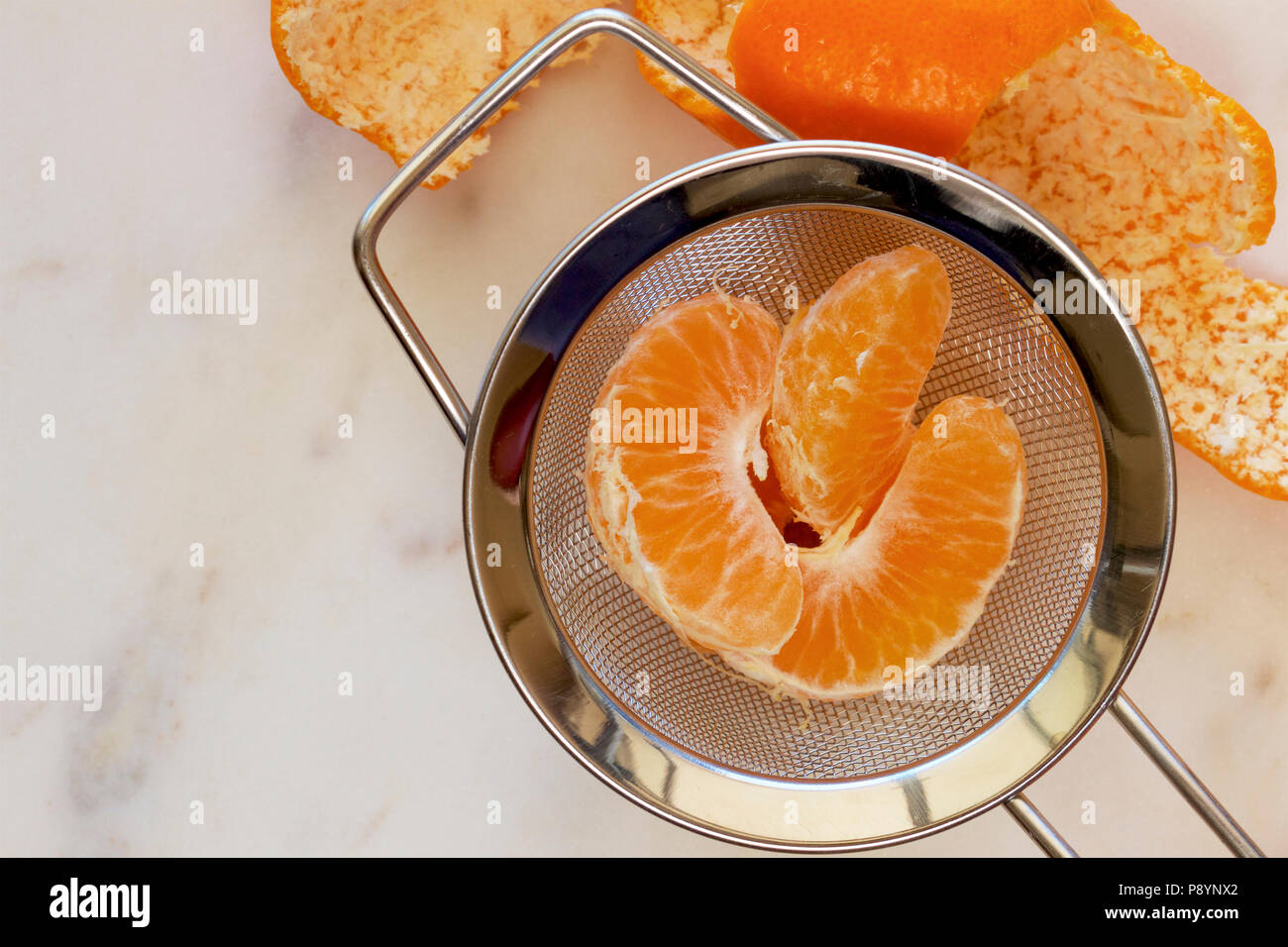 Mandarin segmenti in un setaccio da cucina. Foto Stock