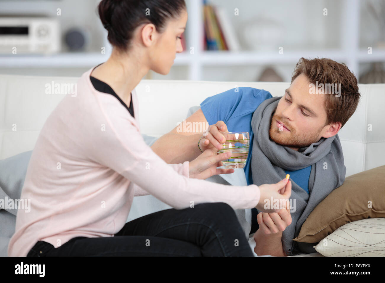 Donna prendendo cura del suo fidanzato con infezioni della gola Foto Stock
