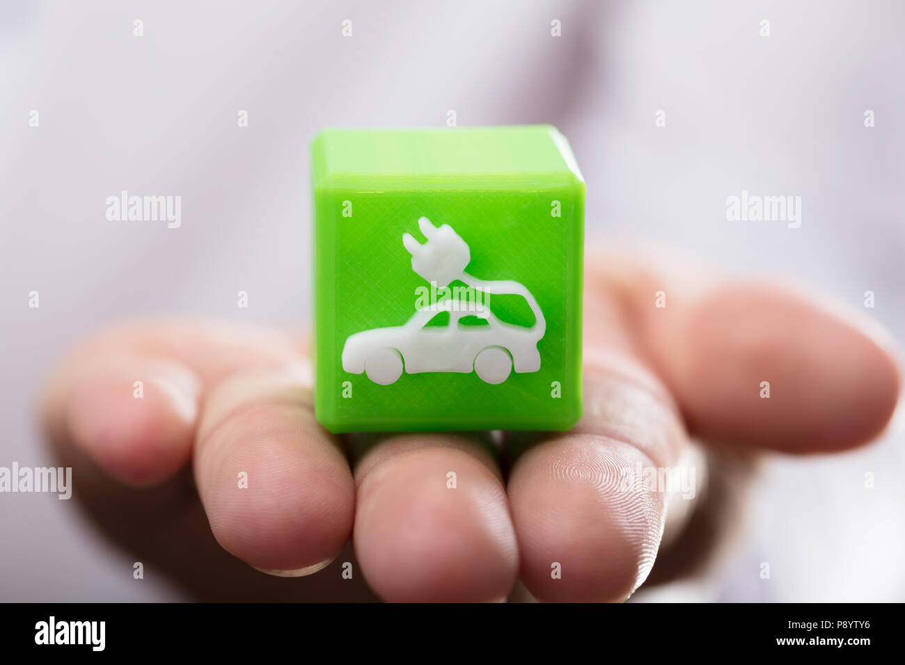 Close-up di mano di una persona azienda verde blocco cubico con eco car icona Foto Stock