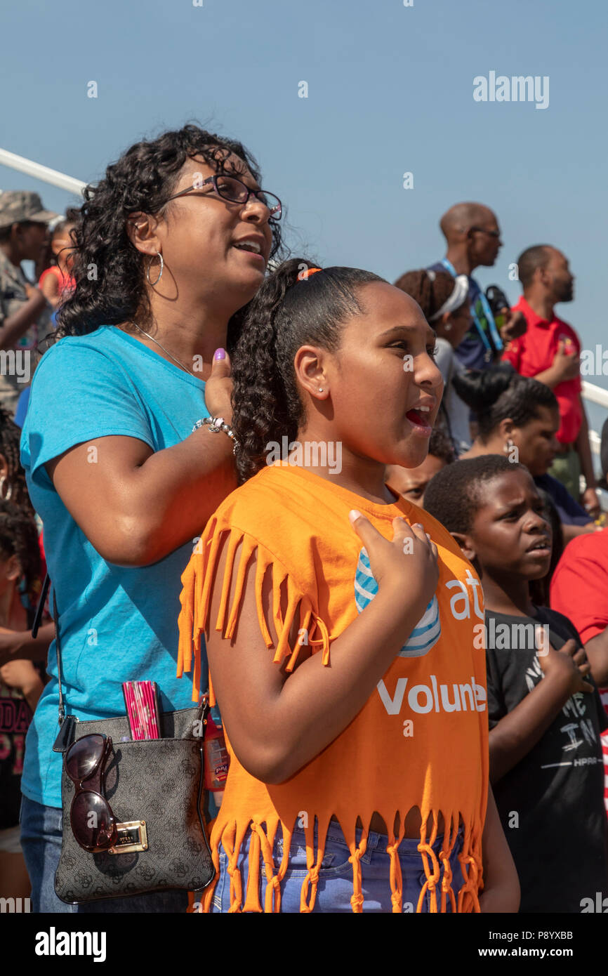 Detroit, Michigan - una madre e figlia cantare l'Inno Nazionale alla Metropolitana Detroit Giornata della Gioventù. Migliaia di bambini di età compresa tra 8-15 partecipare alla manifestazione annuale Foto Stock