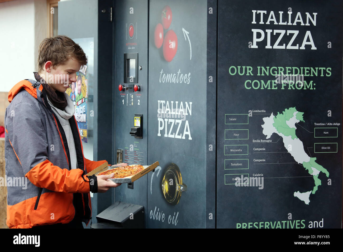 Riscone, Italia, ragazzo orgogliosamente guarda al suo pizza tirata fuori una macchina Foto Stock