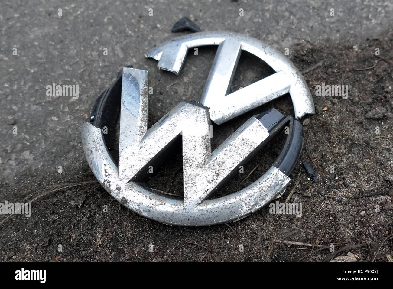 Berlino, Germania, rotto la griglia del grill emblema di una Volkswagen è situato sul ciglio della strada Foto Stock