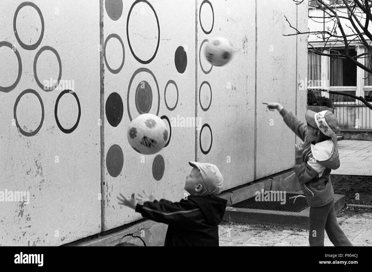 Berlino, gdr, ragazzi gettando Baelle in un asilo nido contro una parete di obiettivo Foto Stock