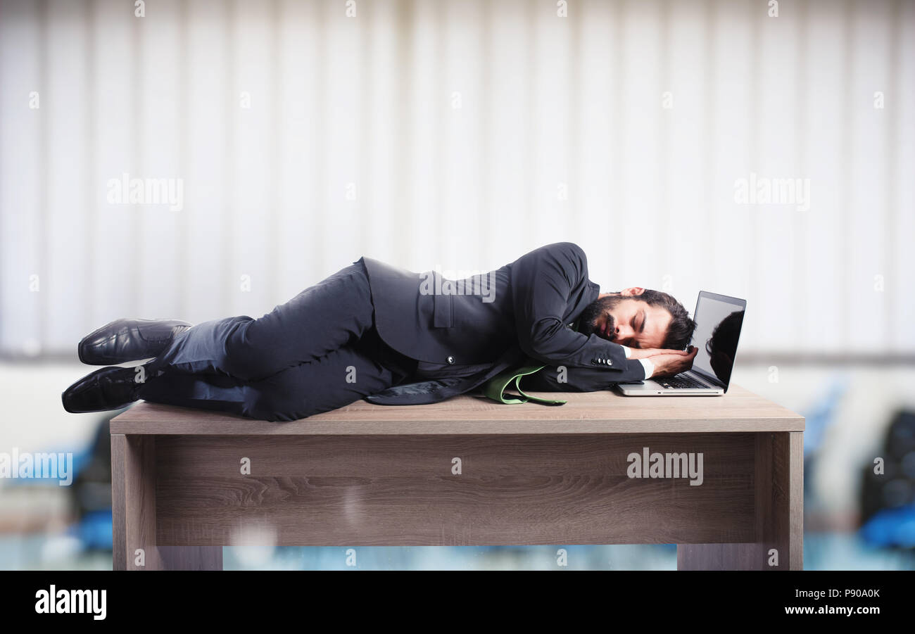 Imprenditore dormendo su una scrivania a causa di sovraccarico di lavoro Foto Stock
