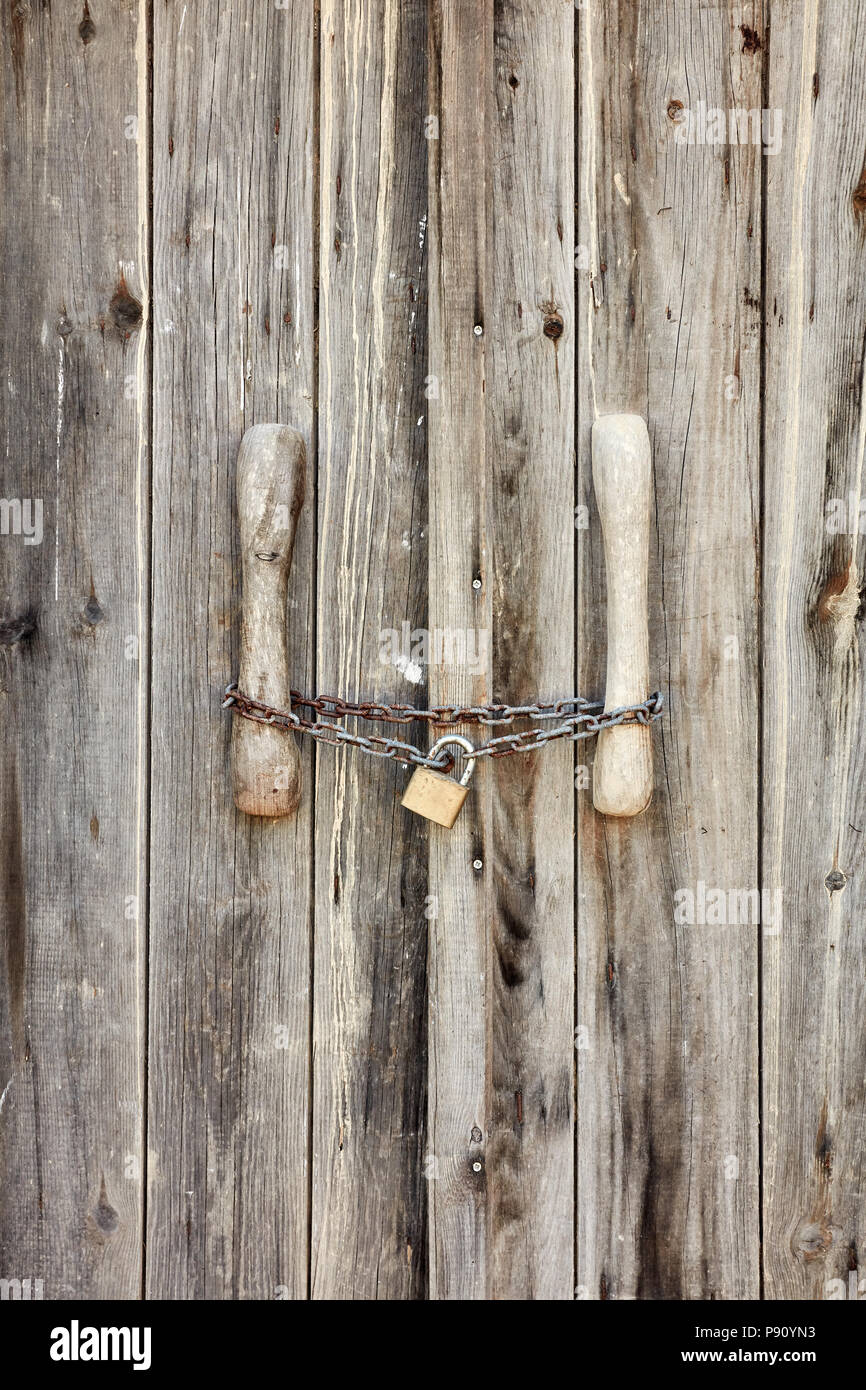 Vecchia porta di legno bloccato con rusty catena e lucchetto Foto Stock