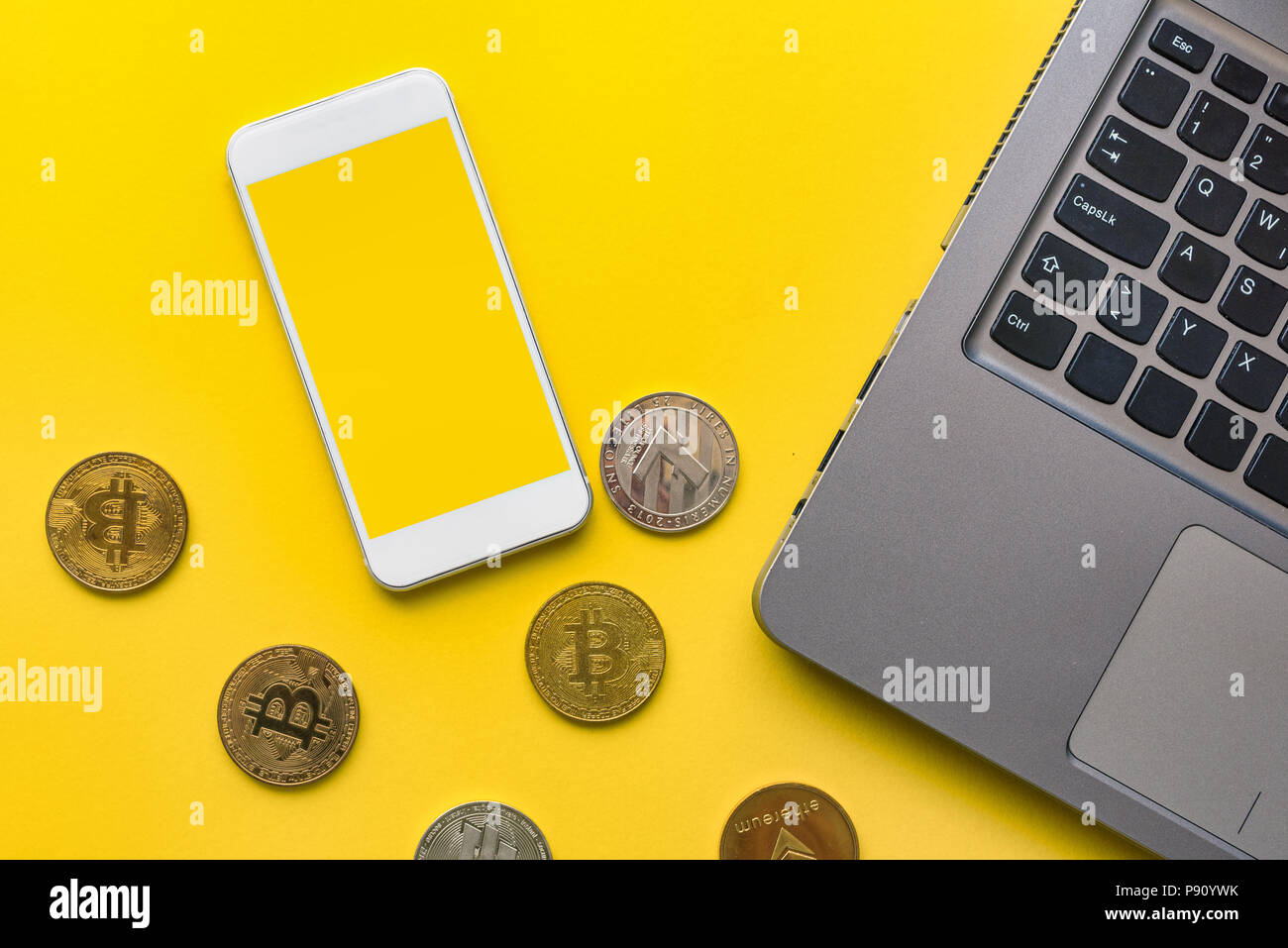 Cryptocurrency concetto di trading, vista dall'alto di smart phone con vuoto mock up schermo, crypto cambio monete e il computer portatile Foto Stock