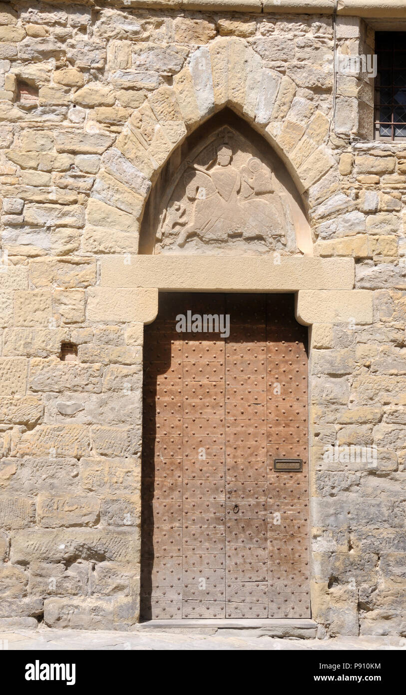 Un portale con un bassorilievo di un cavaliere a cavallo nel timpano, ad Arezzo, Toscana, Italia Foto Stock