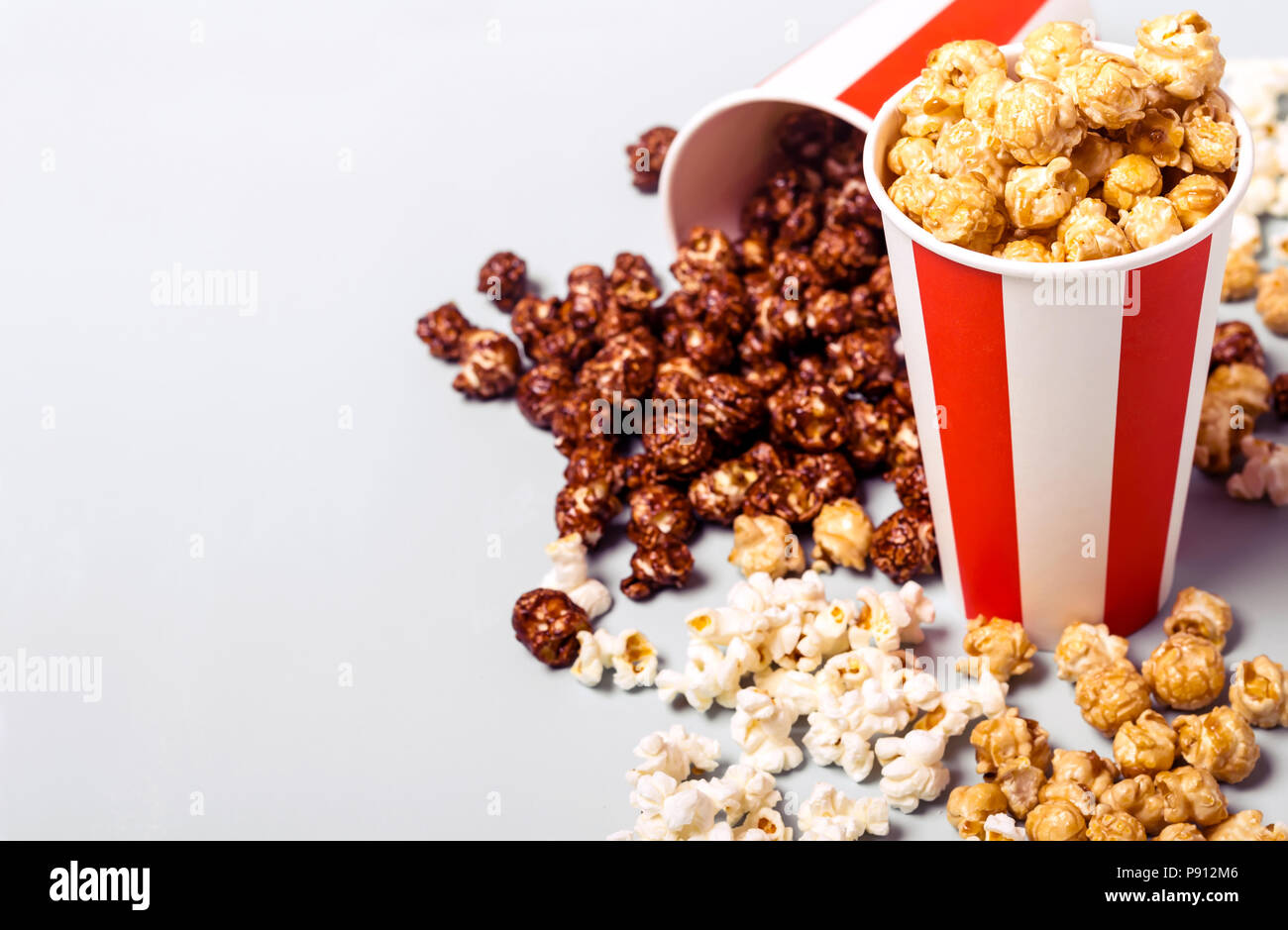 Popcorn assortiti in set di strisce di carta bianco rosso coppa. Il dolce e il salato di popcorn. Foto Stock