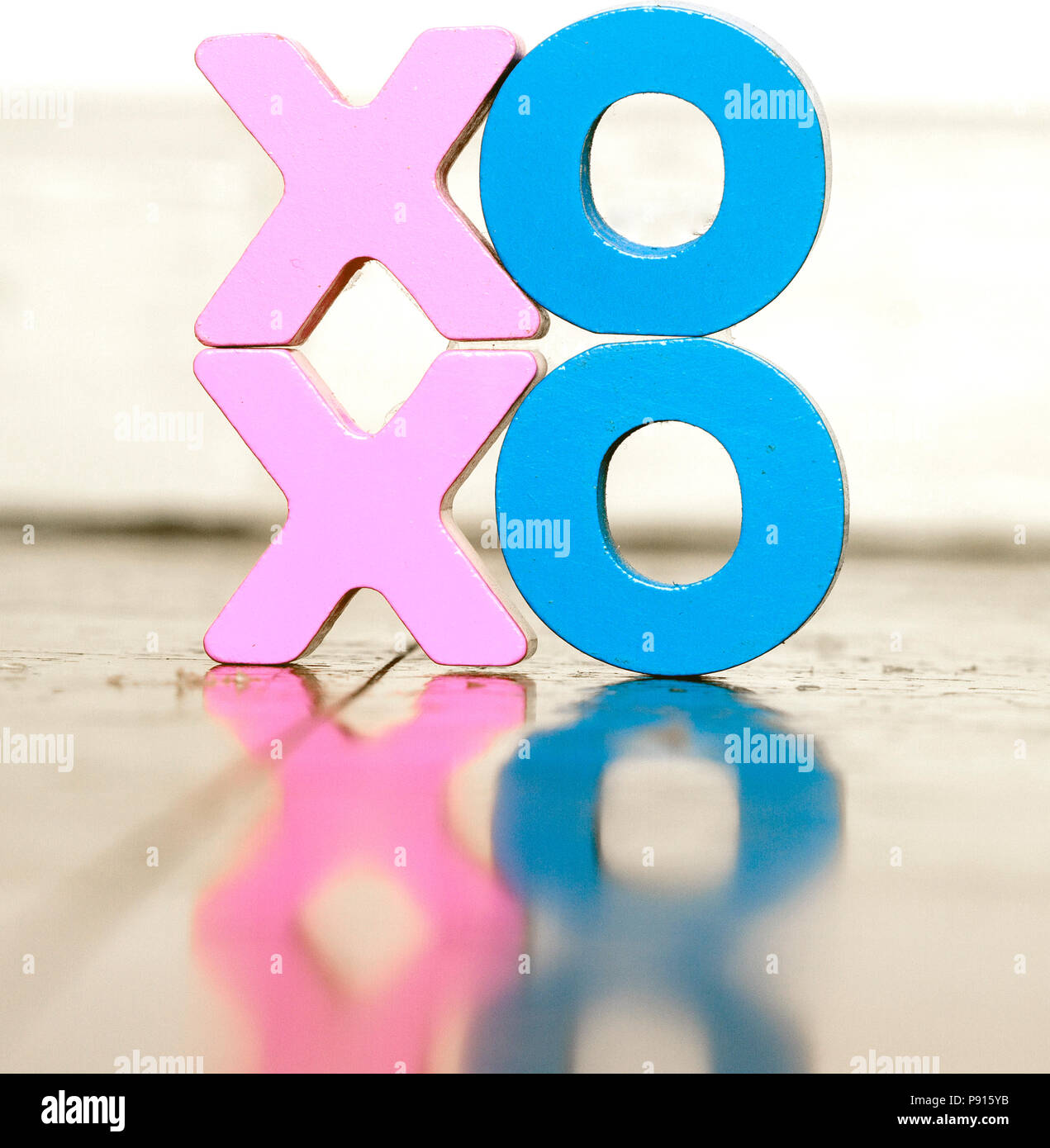 XO XO lettere in legno su un vecchio pavimento in legno con la riflessione colore soffice Foto Stock