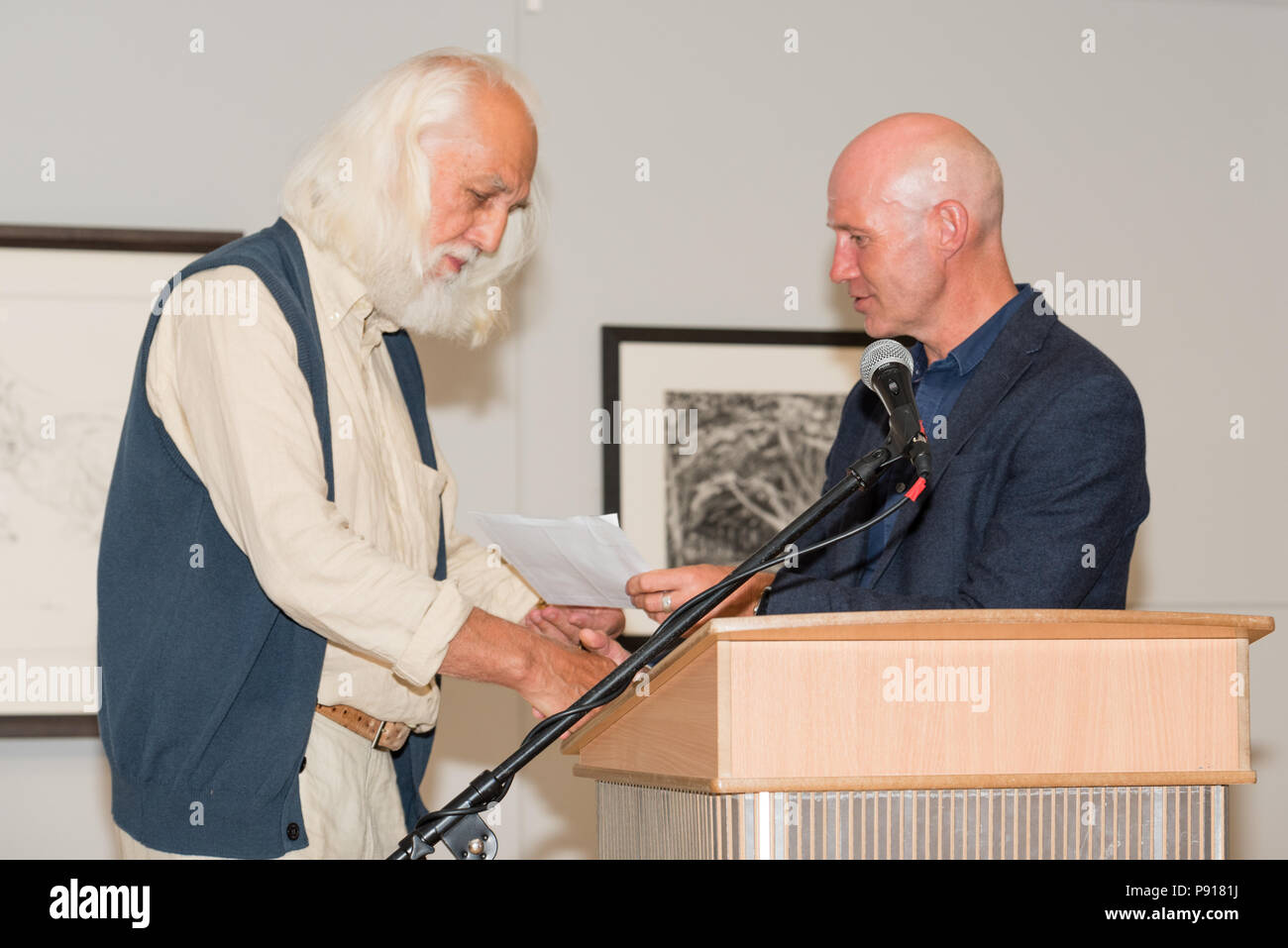 Oriel Môn, Llangefni, Gwynedd, Wales, Regno Unito. Venerdì 13 Luglio 2018. La serata di apertura e la consegna del premio per il centenario e la quarta Kyffin Williams Premio disegno mostra, sponsorizzata da ITV Cymru Wales e Rogers Jones auctioneers, è stato tenuto a Oriel Môn, con Colin See-Paynton (L) ricevente il 2018 Kyffin Williams premio di disegno da Phil Henfrey Capo di News ITV Cymru (R) per il suo disegno 'Six marzo lepri'. Credito: Michael Gibson/Alamy Live News Foto Stock