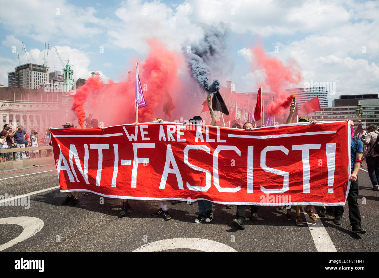 Londra, Regno Unito. 14 Luglio, 2018. Anti-fascisti tenere granate fumogene come essi marzo attraverso Westminster Bridge per opporsi all'estrema destra di 'Free Tommy' (Robinson) e Trump sostenitori" "Benvenuti Trump' marche. Ci sono stati alcuni scontri come antifascista di marzo è stato attaccato da libero Tommy sostenitori sul bordo della piazza del Parlamento. Credito: Mark Kerrison/Alamy Live News Foto Stock