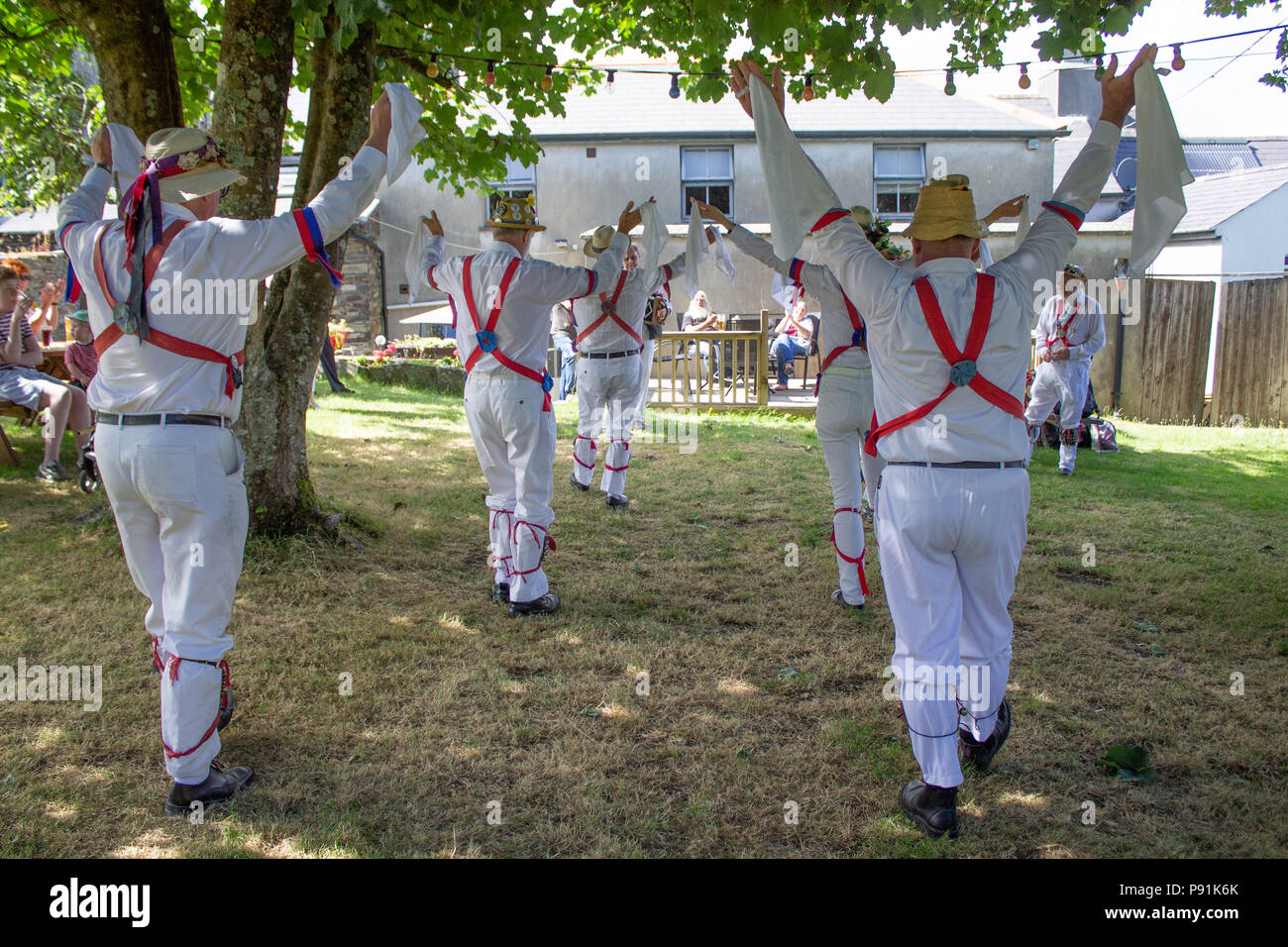 Castletownshend, Irlanda. 14 Luglio, 2018. Gli antichi uomini Morris ballerini in un tour del West Cork & South Kerry fermò a Castletownshend per eseguire sotto gli alberi di mele di Lills Bar diverse ben noto siccità danze di rottura!! Speriamo che le prestazioni porterà le piogge. Credito: aphperspective/Alamy Live News Foto Stock