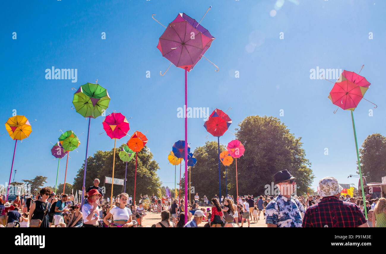 Un ombrello coloratissimo installazione a tema presso la Latitude Festival, con la folla dei frequentatori del festival, Henham Park, Suffolk, Inghilterra, 14 luglio, 2018 Foto Stock
