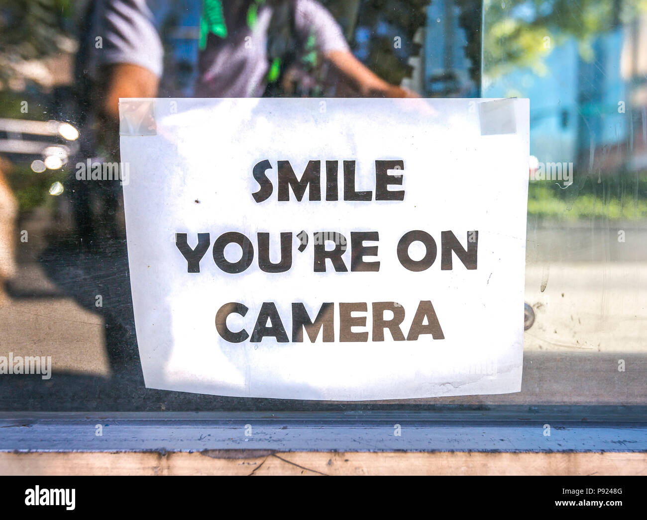 Smile sei sul segno della fotocamera al di fuori del negozio Foto Stock