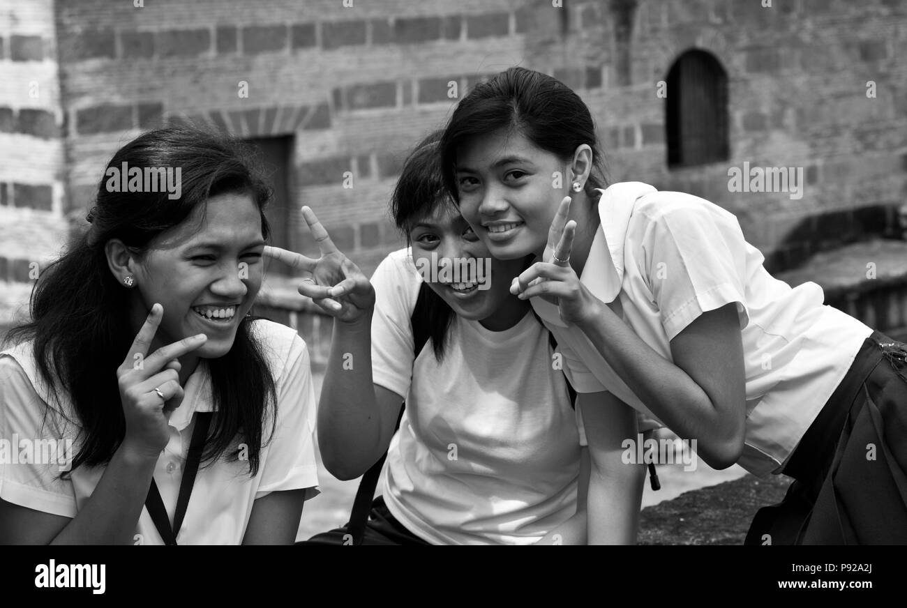 Le ragazze della scuola in flash uniforme il segno di pace in Intramuros - Manila, Filippine Foto Stock