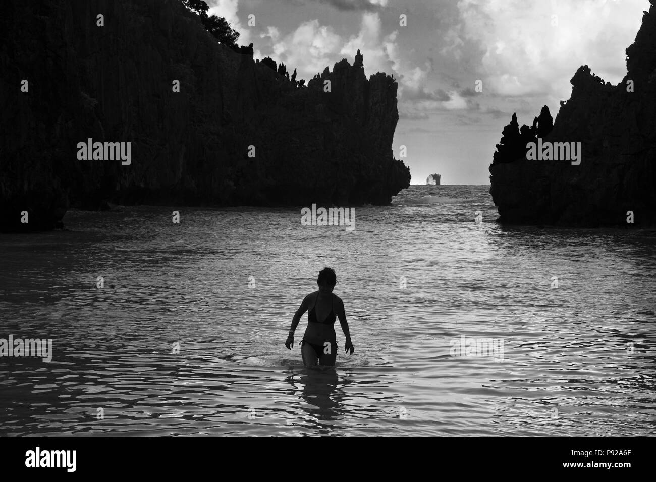 Nuotare in una spiaggia appartata sul MATINLOC isola nei pressi di El Nido nell'arcipelago BACUIT - isola di Palawan, Filippine Foto Stock