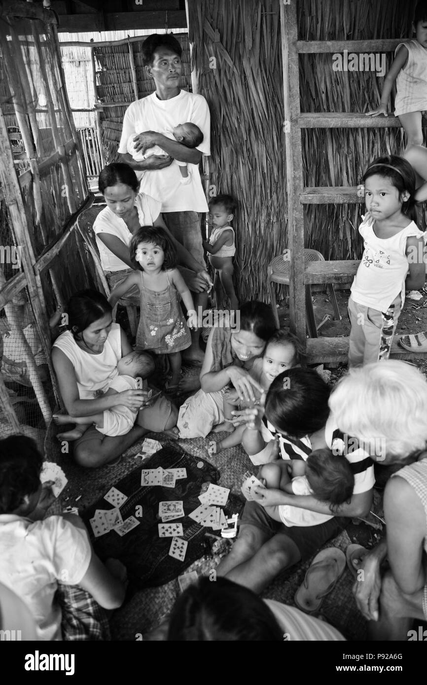 Filippini di giocare a carte in un piccolo villaggio di pescatori a nord di El Nido - isola di Palawan, Filippine Foto Stock