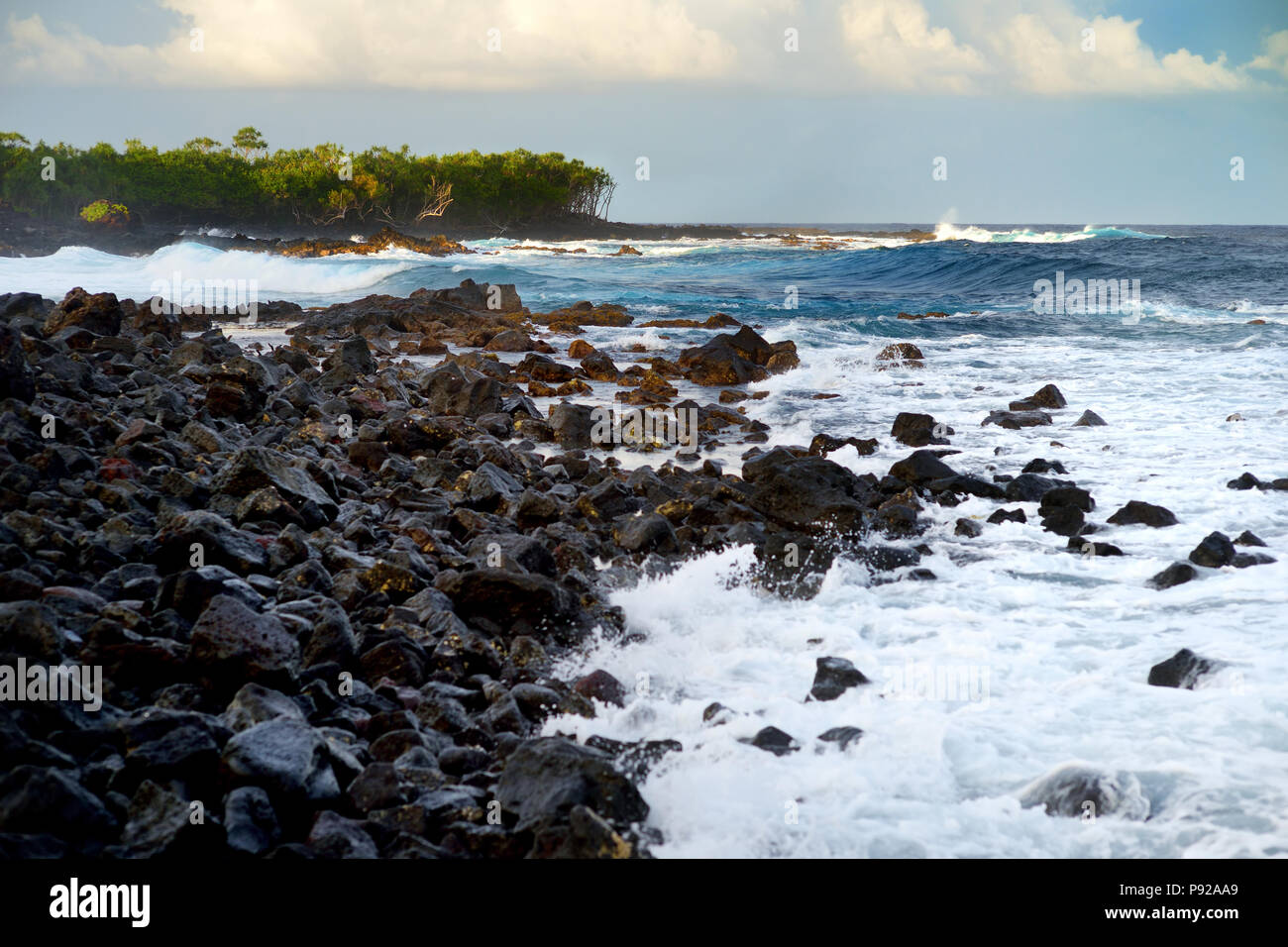 Di un bel colore rosa colorato di onde che si infrangono sulla spiaggia rocciosa di sunrise sulla costa est della Big Island delle Hawaii, STATI UNITI D'AMERICA Foto Stock