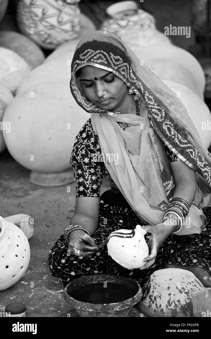 Una donna di Rajasthani dipinge una pentola di creta per il festival GANGUR in JOHDPUR - Rajasthan, India Foto Stock