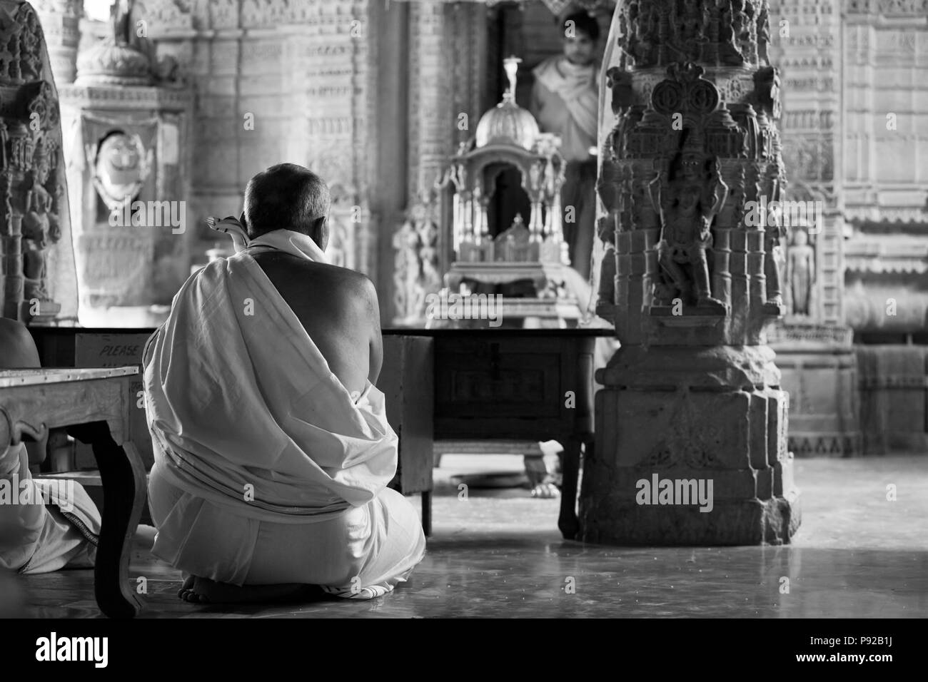 Un devoto di Jain rende una preghiera all'interno di un tempio Jain in Forte di Jaisalmer - Rajasthan, India Foto Stock