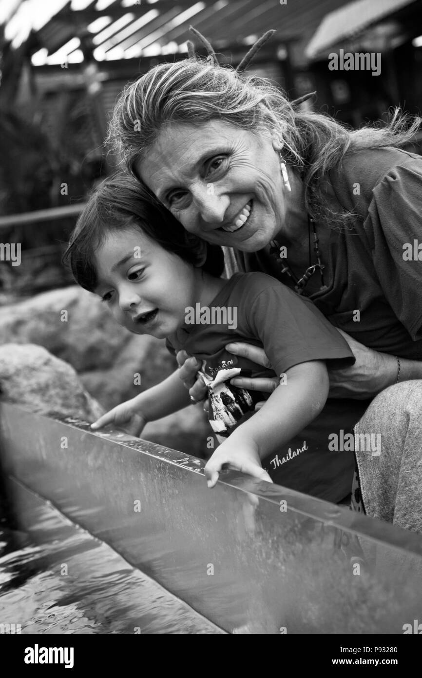 Un giovane metà metà Thai bambino americano con sua nonna - Aquarium di Rayong, Thailandia MR Foto Stock