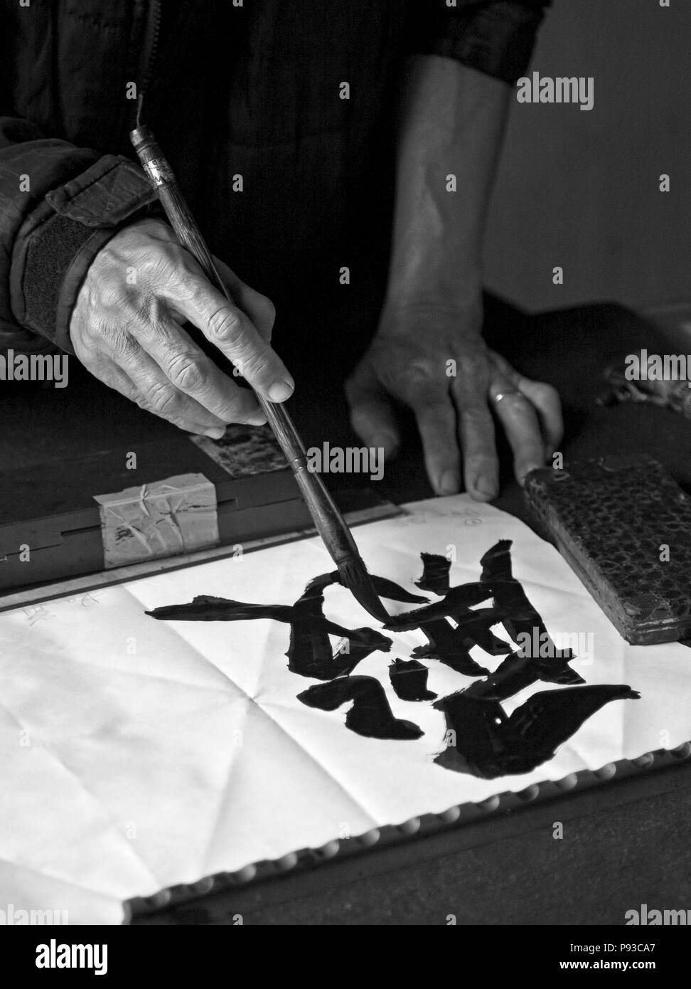 Un artista dipinge caratteri tradizionali all'interno della NGOC SON TEMPLE nel vecchio quartiere - Hanoi, Vietnam Foto Stock