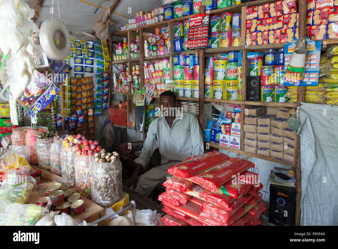 Kakuma, Kenya - un fornitore si siede in un piccolo negozio di alimentari nella città di Kakuma. Foto Stock