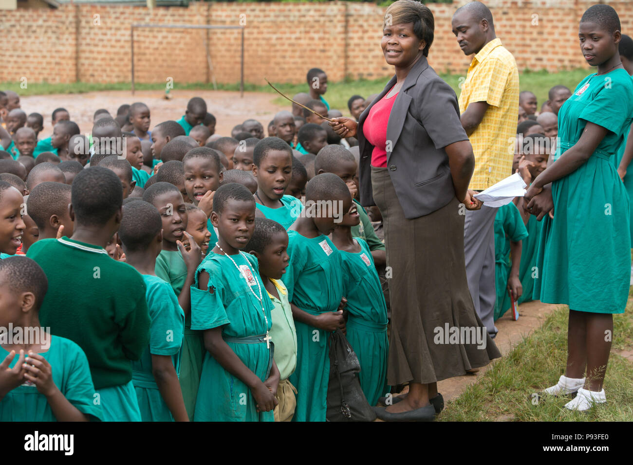 Bombo, Uganda - un insegnante conduce una scuola appello nella schoolyard di San Giuseppe Bombo misti scuola primaria. Foto Stock Bombo, Uganda - un insegnante conduce una scuola appello nella schoolyard di San Giuseppe Bombo misti scuola primaria. Foto Stock