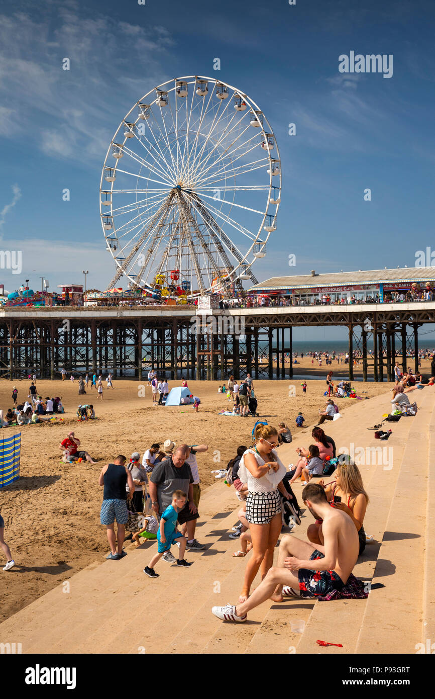 Regno Unito, Inghilterra, Lancashire, Blackpool, visitatori rilassante nella luce del sole sulla parete del mare passi dal molo centrale Foto Stock