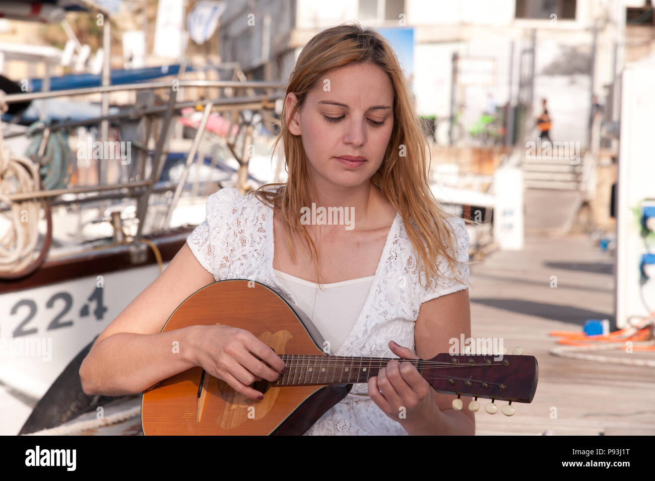 La bionda signora suonare la chitarra Foto Stock