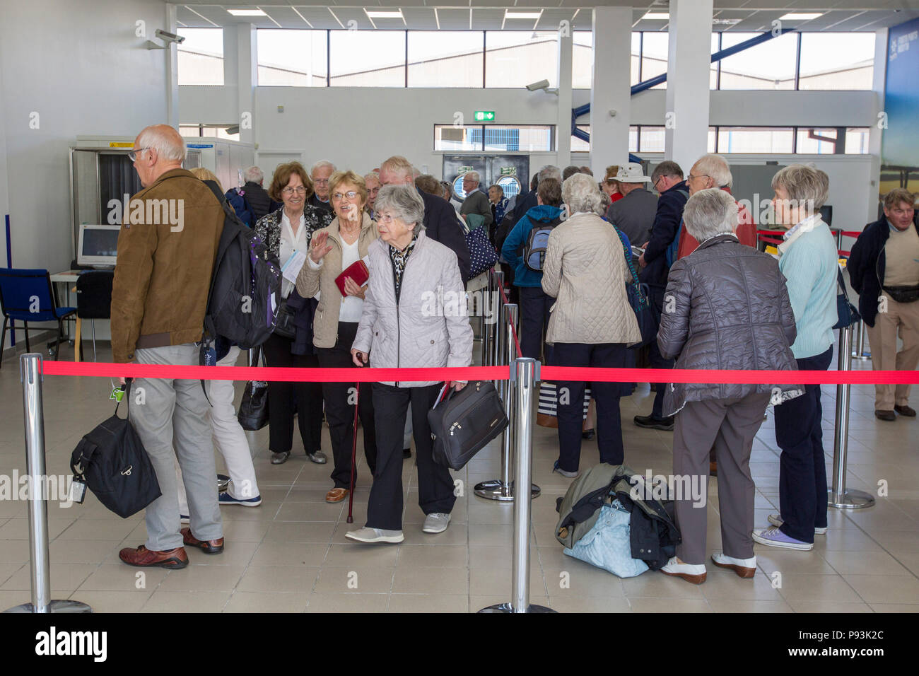 Gli anziani in coda per nave da crociera Foto Stock