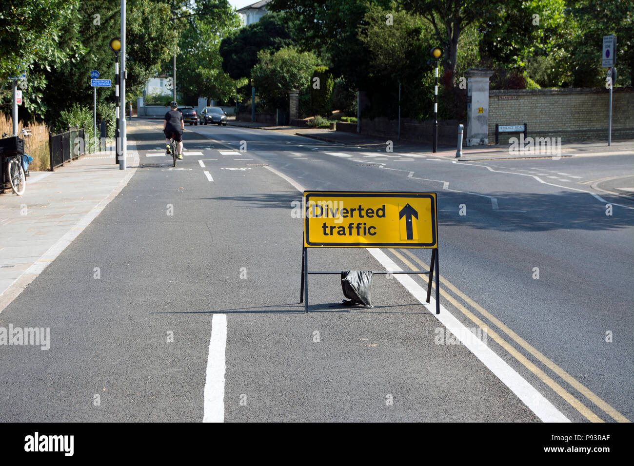 Traffico deviato dritto firmare in un ciclo di segregarted lane, con ciclista a metà distanza, a Kingston upon Thames Surrey, Inghilterra Foto Stock