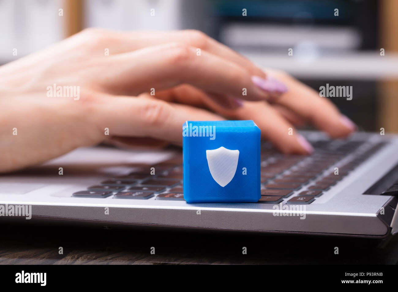 Imprenditrice la mano lavorando sul computer portatile con blocco cubico mostrando sicurezza simbolo dello schermo Foto Stock