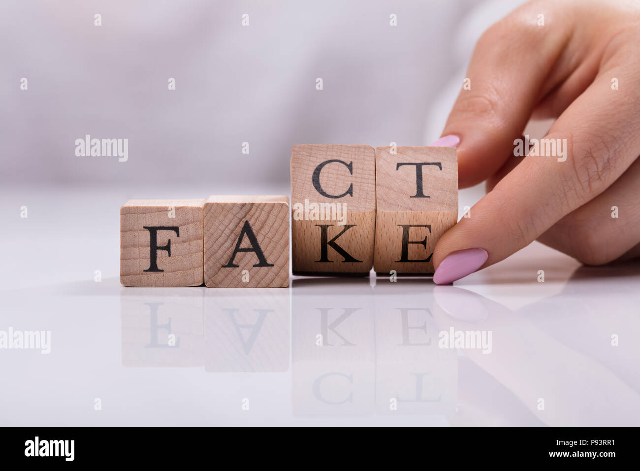 Imprenditrice di sostituzione a mano in legno blocchi cubici da fingere di fatto parola Foto Stock