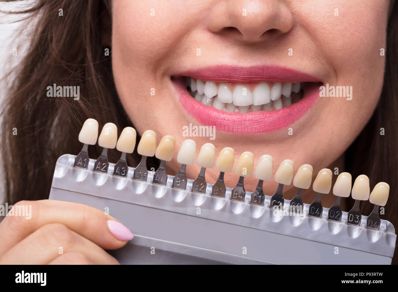 Close-up di una donna sorridente Holding di impianti con varie sfumature di tono Foto Stock