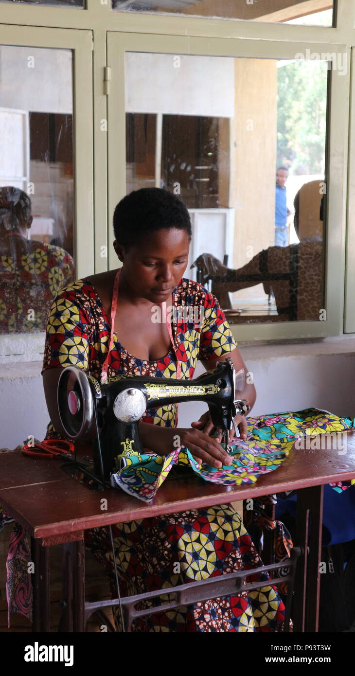 Donna africana in abito tradizionale con macchina da cucire manuale, ritratto, Musanze, Ruanda, Africa Foto Stock