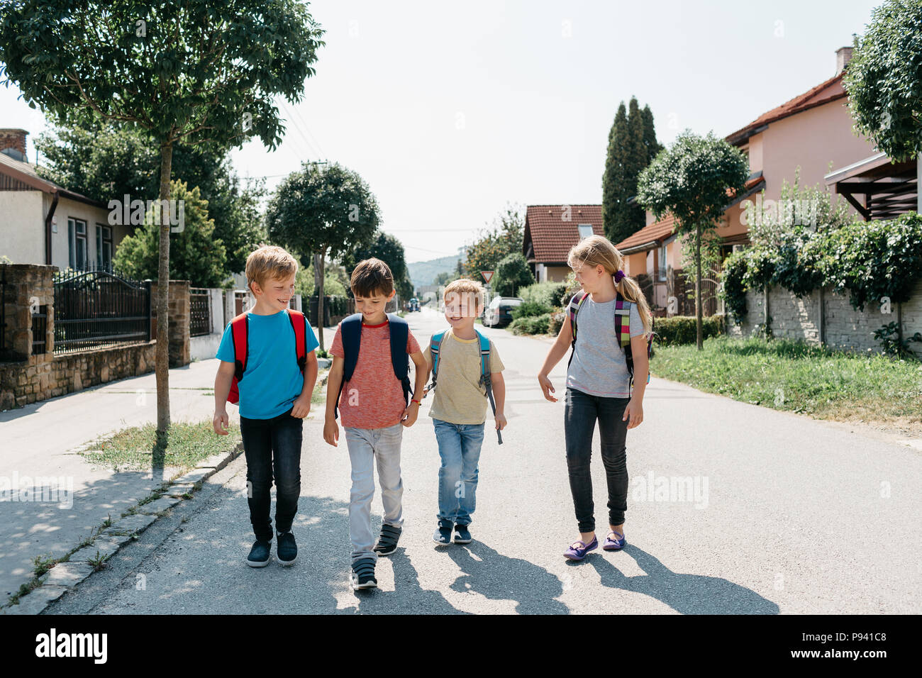 A scuola i bambini andare a scuola a piedi non accompagnati da un adulto. I compagni di scuola per andare a casa da scuola sulle proprie di parlarsi. Foto Stock