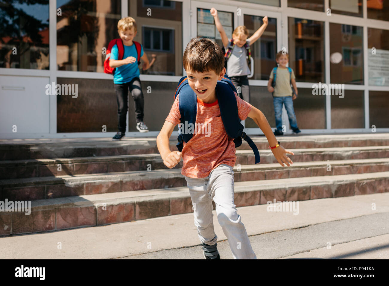 Dei bambini felici di fuggire dalla scuola. Ultimo giorno di scuola - Ritratto di un bambino allegro scappando dalla scuola. Foto Stock