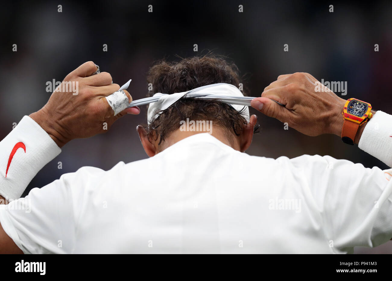 Rafael Nadal regola la sua fascia Nike durante la sua partita contro Novak  Djokovic il giorno undici dei campionati di Wimbledon al All England Lawn  Tennis e Croquet Club, Wimbledon. Stampa foto