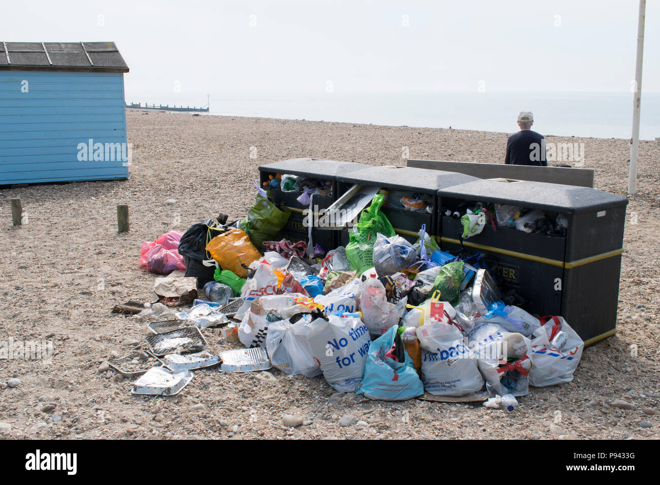 Traboccante bidoni della spazzatura sulla spiaggia Bandiera Blu, Hayling Island, Hampshire, dopo un soleggiato weekend festivo Foto Stock