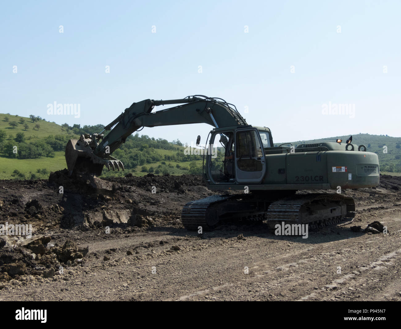 Un rumeno Forze terrestri soldato scava una fossa di scarico utilizzando un escavatore in collaborazione con l'Ingegnere 961st Company, U.S. Esercito di riserva, durante la loro decisa Castello 2018 rotazione in corrispondenza del giunto National Training Centre, Cincu, Romania, Luglio 6, 2018. I due componenti militari hanno lavorato insieme per il cross-treno su apparecchiature e tecnico completo di progetti a sostegno della Atlantic risolvere. (U.S. Esercito nazionale Guard foto di Sgt. 1. Classe Kimberly D. Calkins) Foto Stock