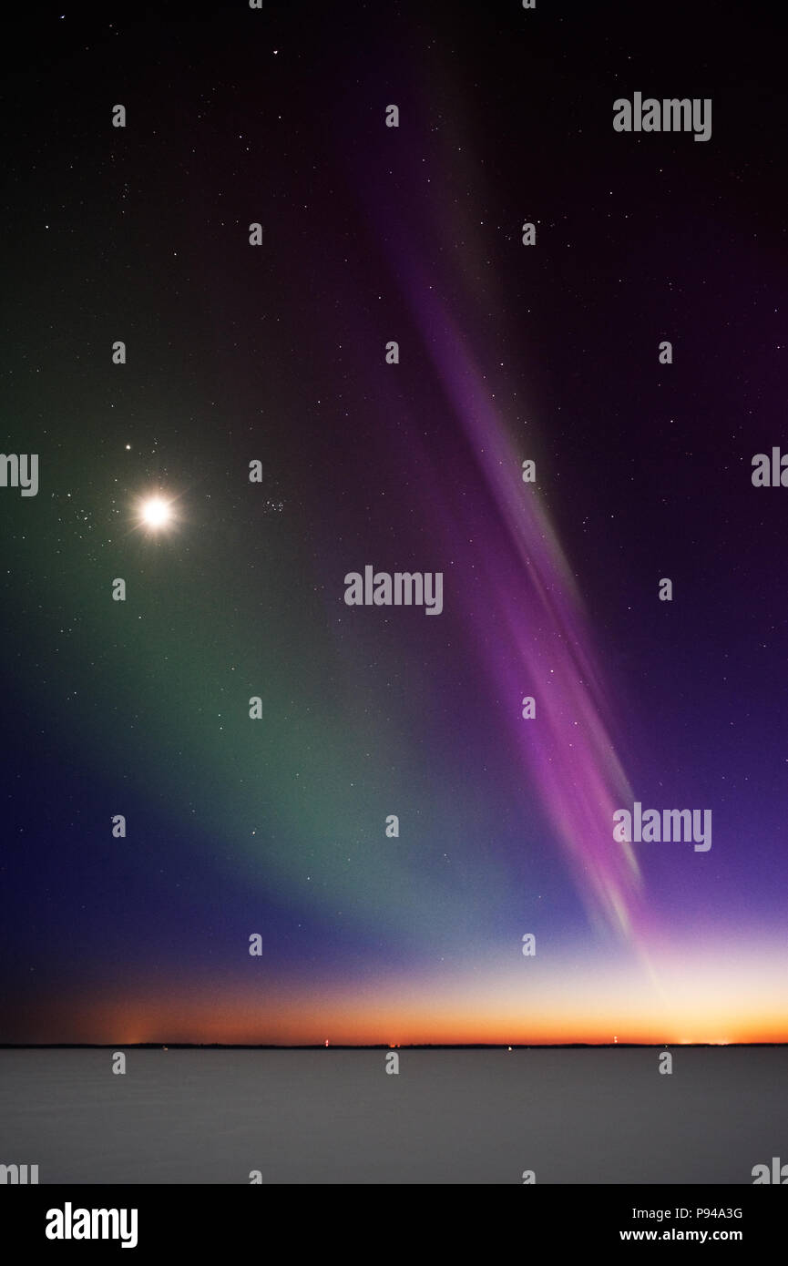Display brillante di luci del nord e la luna sopra il lago di congelati dopo il tramonto. 15 sec di esposizione con elevata ISO 800. Moderato livello di rumore. Foto Stock