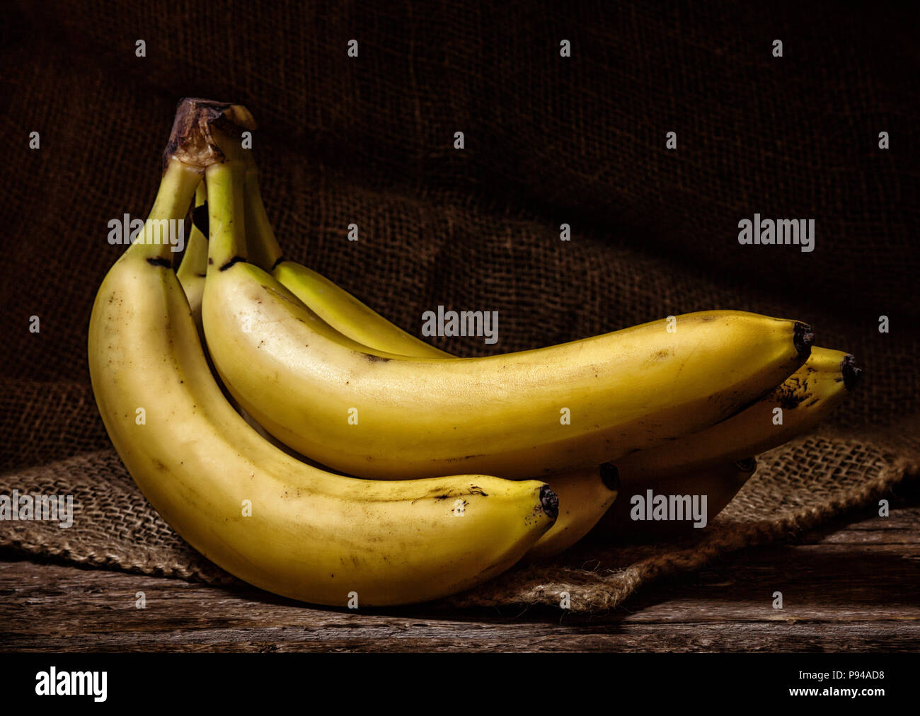 Fresche e mature banane gialle su una tavola di legno. Foto Stock